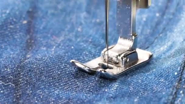 Gros plan sur les vêtements de jeans à coudre sur la machine à coudre  