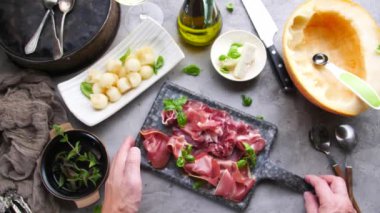 kavun ve Prosciutto ile lezzetli İtalyan yemek hazırlamak kişi kırpılmış çekim