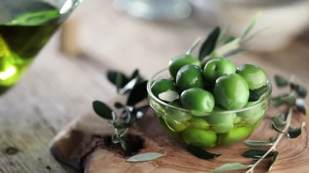Nahaufnahme Von Frischen Grünen Oliven Und Olivenöl Auf Einem Holztisch — Stockvideo