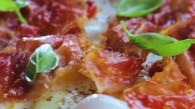 Domuz pastırmalı, domatesli ve fesleğenli yumurta kızartma tavasında pişmiş.  