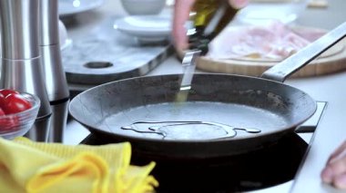 Kızartma tavasına organik yağ döken kişinin kısmi görüntüsü