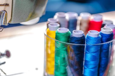 Kumaş dikiş için nesneleri ve çeşitli türleri. Çok renkli kumaş, iplik makaraları, iğneler, bir dikiş pençe için dikiş giyim ihtiyaç vardır.