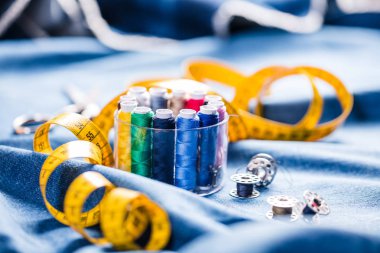 Kumaş dikiş için nesneleri ve çeşitli türleri. Çok renkli kumaş, iplik makaraları, iğneler, bir dikiş pençe için dikiş giyim ihtiyaç vardır.