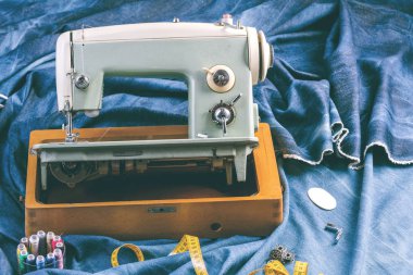 Dikiş makinesi ile çivit kot pantolon dikmek, giyim endüstrisi konsepti