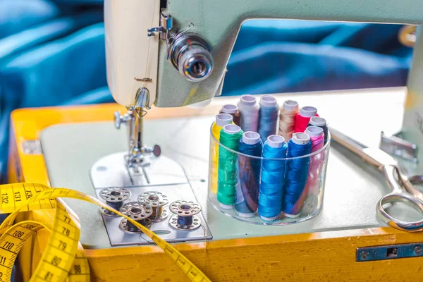 Fabric of various types and objects for sewing. Multicolored fabric, thread reels, needles, a sewing paw are needed for sewing clothes.