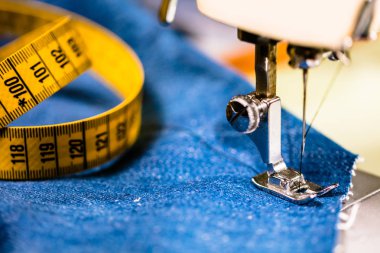 Dikiş makinesiyle kot pantolon dikmek. Kotları dikiş makinesiyle onar. Değişim kotu, kot pantolon paça, el yapımı endüstriyel konsept.