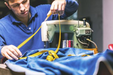 Dikiş makinesiyle kot pantolon dikmek. Kotları dikiş makinesiyle onar. Değişim kotu, kot pantolon paça, el yapımı endüstriyel konsept.