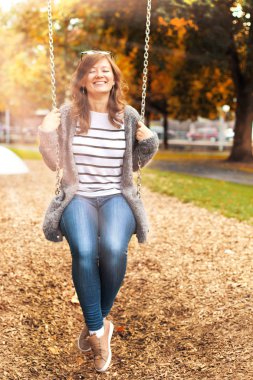 Bahçesi, salıncak üzerinde dinlenme gülümseyen güzel kadın