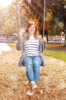 Bahçesi, salıncak üzerinde dinlenme gülümseyen güzel kadın