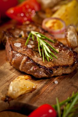 Biberiye ve sarımsak ahşap masa üzerinde taze lezzetli ızgara biftek