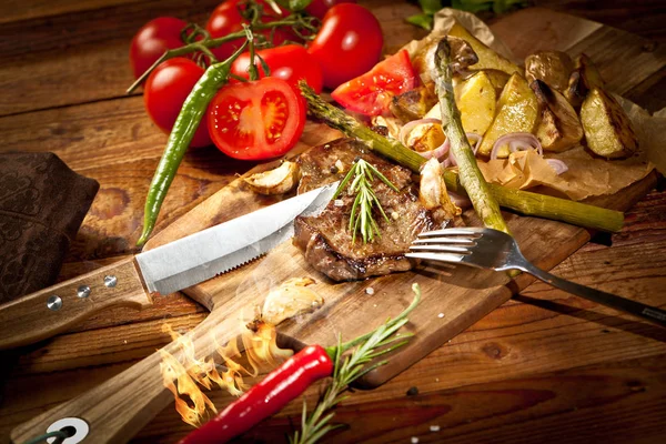 Čerstvé Chutné Grilovaný Biftek Zeleninou Vidlice Nožem Oheň Dřevěný Stůl — Stock fotografie