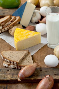 sağlıklı süt ve süt ürünleri, yumurta, dilimlenmiş ekmek ve sebze rustik ahşap yüzey üzerinde