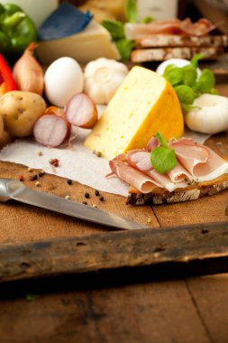 Çeşitli sebze, peynir ve ham ahşap masa, rustik arka plan üzerinde