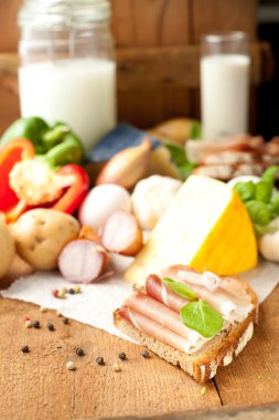 Çeşitli sebze, peynir ve ham ahşap masa, rustik arka plan üzerinde