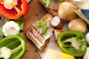 Çeşitli sebze, peynir ve ham ahşap masa, rustik arka plan üzerinde