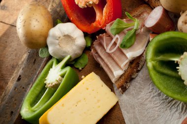 Çeşitli sebze, peynir ve ham ahşap masa, rustik arka plan üzerinde