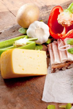 Çeşitli sebze, peynir ve ham ahşap masa, rustik arka plan üzerinde