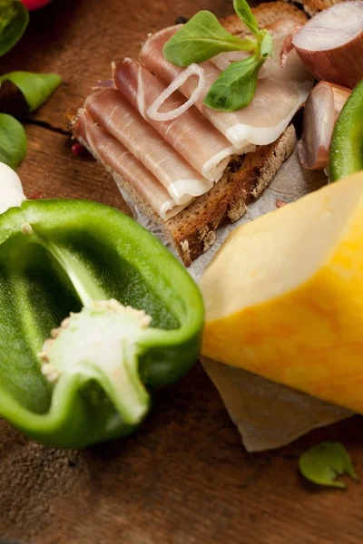 Közelkép Finom Étel Kenyérrel Szeletelt Sonka Sajt Fűszerek Zöldségek Asztalon — Stock Fotó
