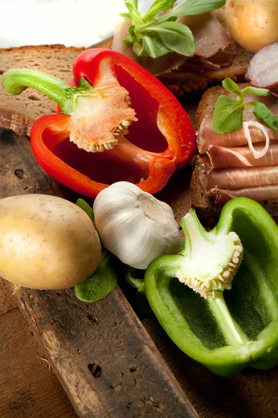 Çeşitli sebze, peynir ve ham ahşap masa, rustik arka plan üzerinde
