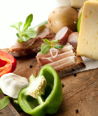 Çeşitli sebze, peynir ve ham ahşap masa, rustik arka plan üzerinde