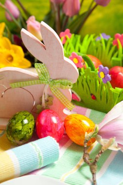 Ahşap Paskalya tavşanı, renkli yumurta ve parlak çiçekler. Paskalya kavramı