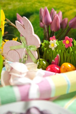 Ahşap Paskalya tavşanı, renkli yumurta ve parlak çiçekler. Paskalya kavramı