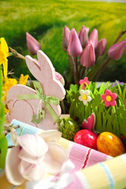 Ahşap Paskalya tavşanı, renkli yumurta ve parlak çiçekler. Paskalya kavramı