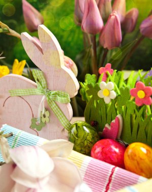 Ahşap Paskalya tavşanı, renkli yumurta ve parlak çiçekler. Paskalya kavramı