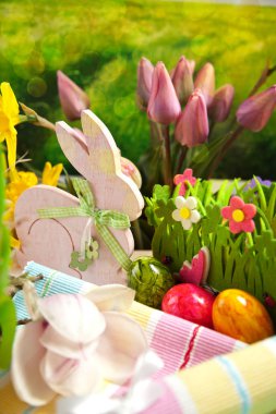 Ahşap Paskalya tavşanı, renkli yumurta ve parlak çiçekler. Paskalya kavramı