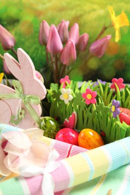 Ahşap Paskalya tavşanı, renkli yumurta ve parlak çiçekler. Paskalya kavramı