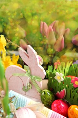 Ahşap Paskalya tavşanı, renkli yumurta ve parlak çiçekler. Paskalya kavramı