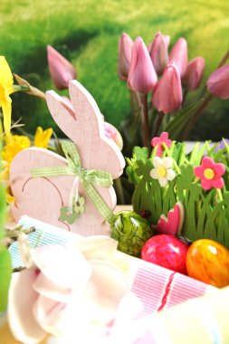 Ahşap Paskalya tavşanı, renkli yumurta ve parlak çiçekler. Paskalya kavramı