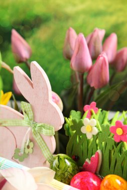 Ahşap Paskalya tavşanı, renkli yumurta ve parlak çiçekler. Paskalya kavramı