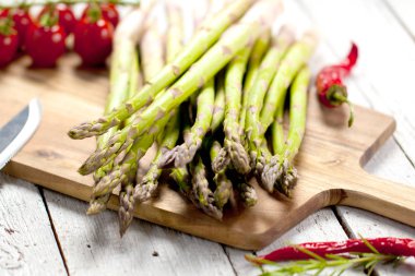Yönetim Kurulu, domates, biber, biberiye ve bıçak üzerinde ahşap masa doğrama üzerinde taze sağlıklı kuşkonmaz
