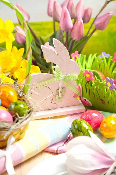 Ahşap Paskalya tavşanı, renkli yumurta ve parlak çiçekler. Paskalya kavramı