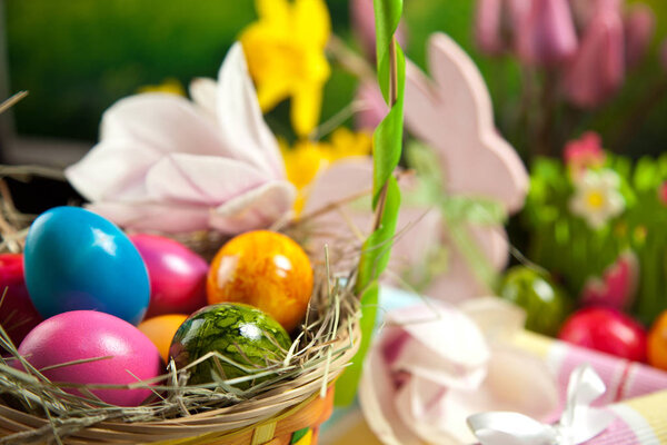 Wooden Easter bunny, colorful eggs and bright flowers. Easter concept