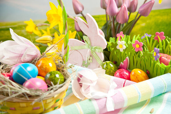 Wooden Easter bunny, colorful eggs and bright flowers. Easter concept