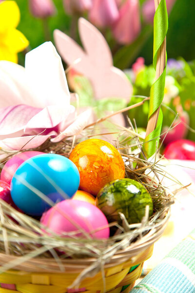 Wooden Easter bunny, colorful eggs and bright flowers. Easter concept