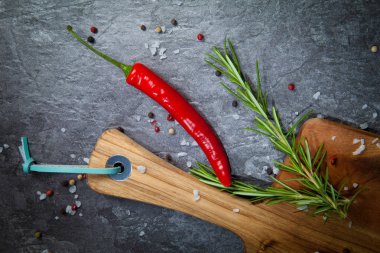 kırmızı biber biber, board, biberiye, tuz ve karabiber gri yüzeyinde Doğrama ahşap Üstten Görünüm