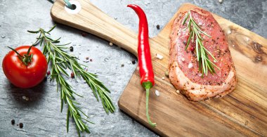 Biber biber, domates ve baharat ahşap tahta üzerinde çiğ et