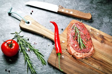 Biber biber, domates ve baharat ahşap tahta üzerinde çiğ et