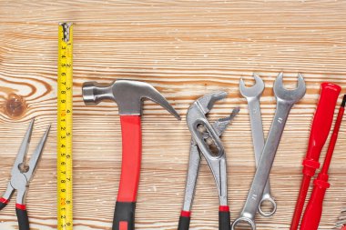 ahşap masa üzerinde çeşitli inşaat araçları üst görünümü, bakım konsepti