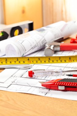 ahşap masa üzerinde çeşitli inşaat araçları ve plan yakın çekim görünümü