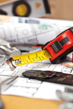 çeşitli inşaat araçlarının yakın çekim görünümü ve masadaki plan, bakım konsepti