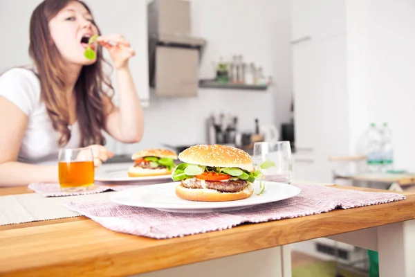 Smakelijke Hamburgers Borden Vrouwen Die Achter Keuken Eten — Stockfoto