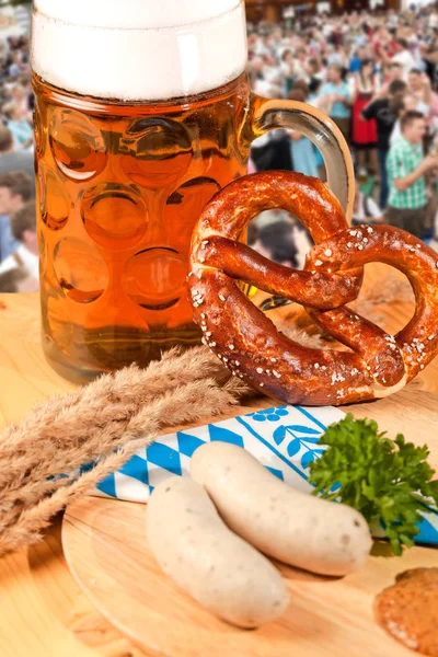 Mug of beer, pretzel and sausages on wooden table. Octoberfest concept
