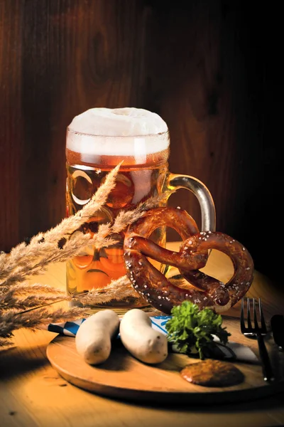 Bira, simit ve sosis ahşap masa üzerinde bir fincan. Octoberfest kavramı