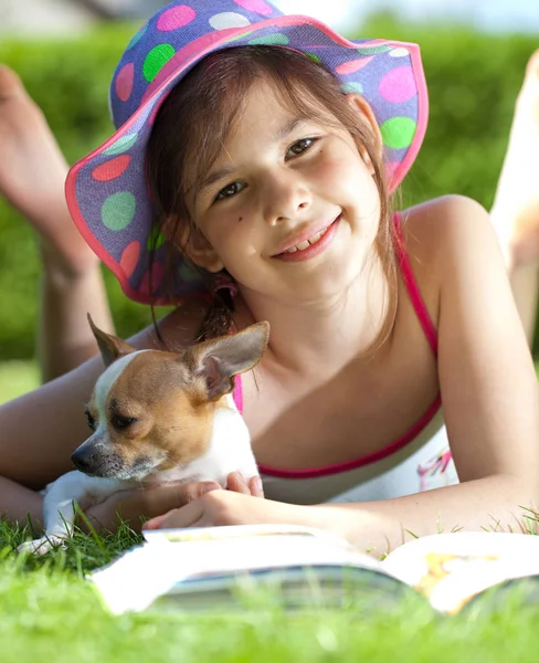 Nettes Mädchen Mit Hund Liegt Auf Grünem Gras Und Liest — Stockfoto