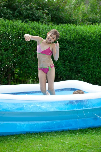 在花园的室外游泳池里穿着泳衣的漂亮姑娘 — 图库照片