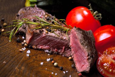Otlar ve baharatlar ile lezzetli biftek bakış ahşap masa üzerinde kapatın